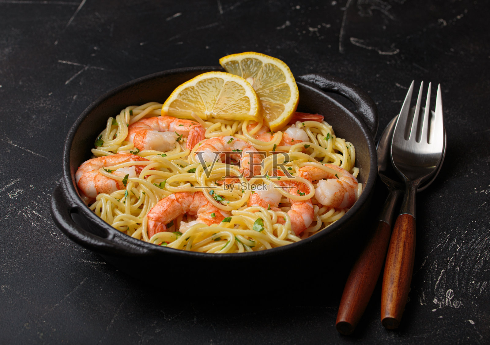 美味的意大利海鲜面配有虾、柠檬和欧芹，黑色背景下的俯视角度照片摄影图片