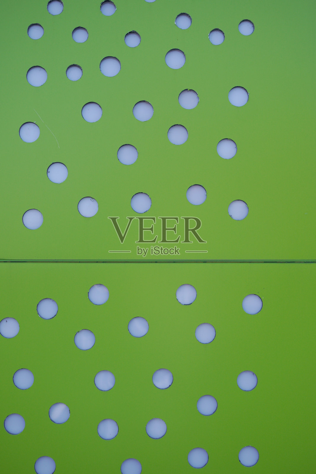 带有均匀圆形孔洞的绿色穿孔板照片摄影图片