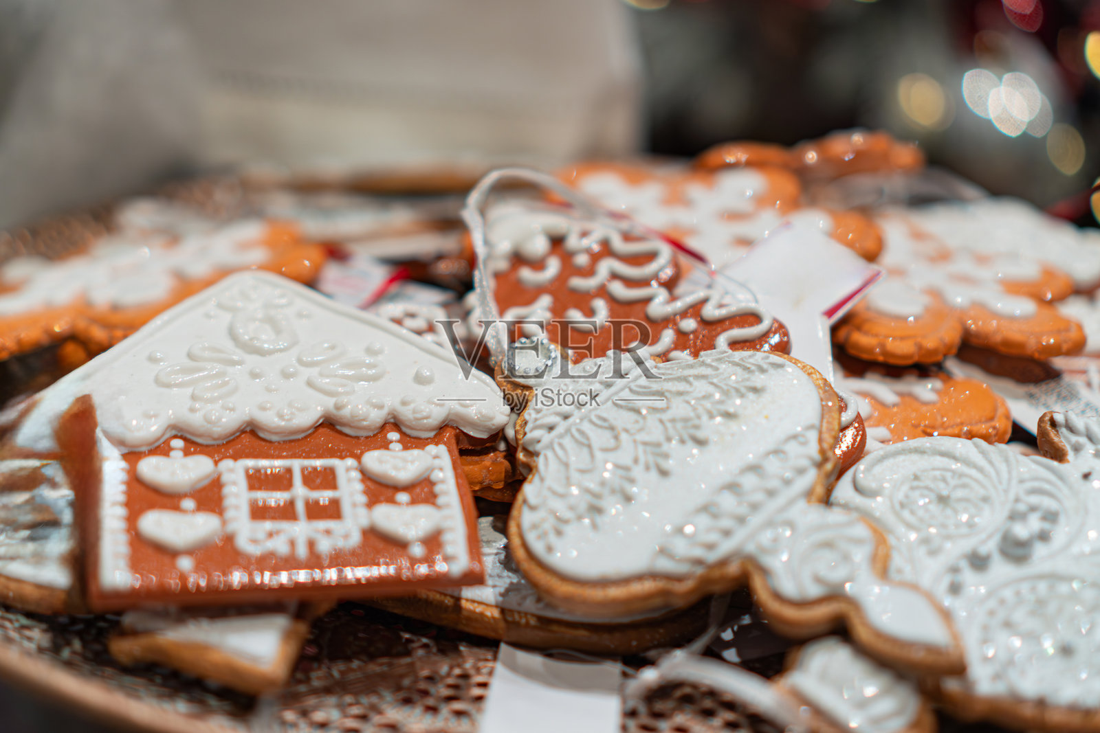 一盘装饰精美的节日曲奇饼干，有各种设计和颜色，以节日为主题。饼干种类繁多，随意摆放，并带有柔和的阴影。照片摄影图片