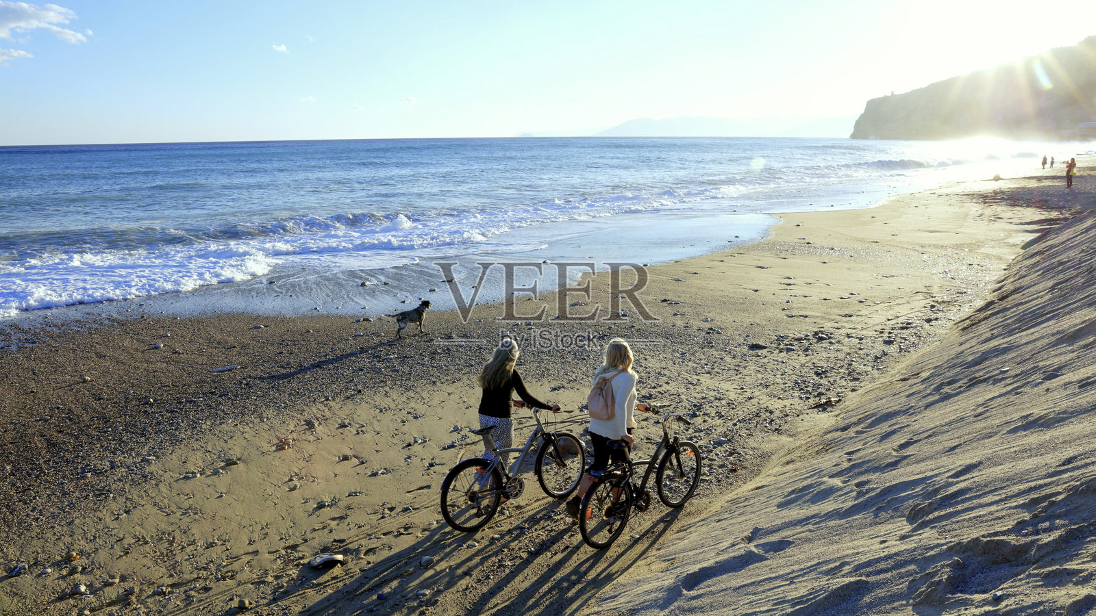 日落时分，成熟的女性在海滩上骑行照片摄影图片