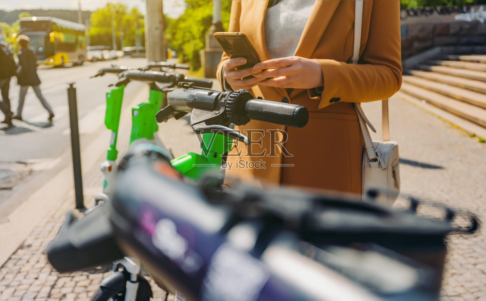 一位女性游客正在通过手机租用电动滑板车。照片摄影图片
