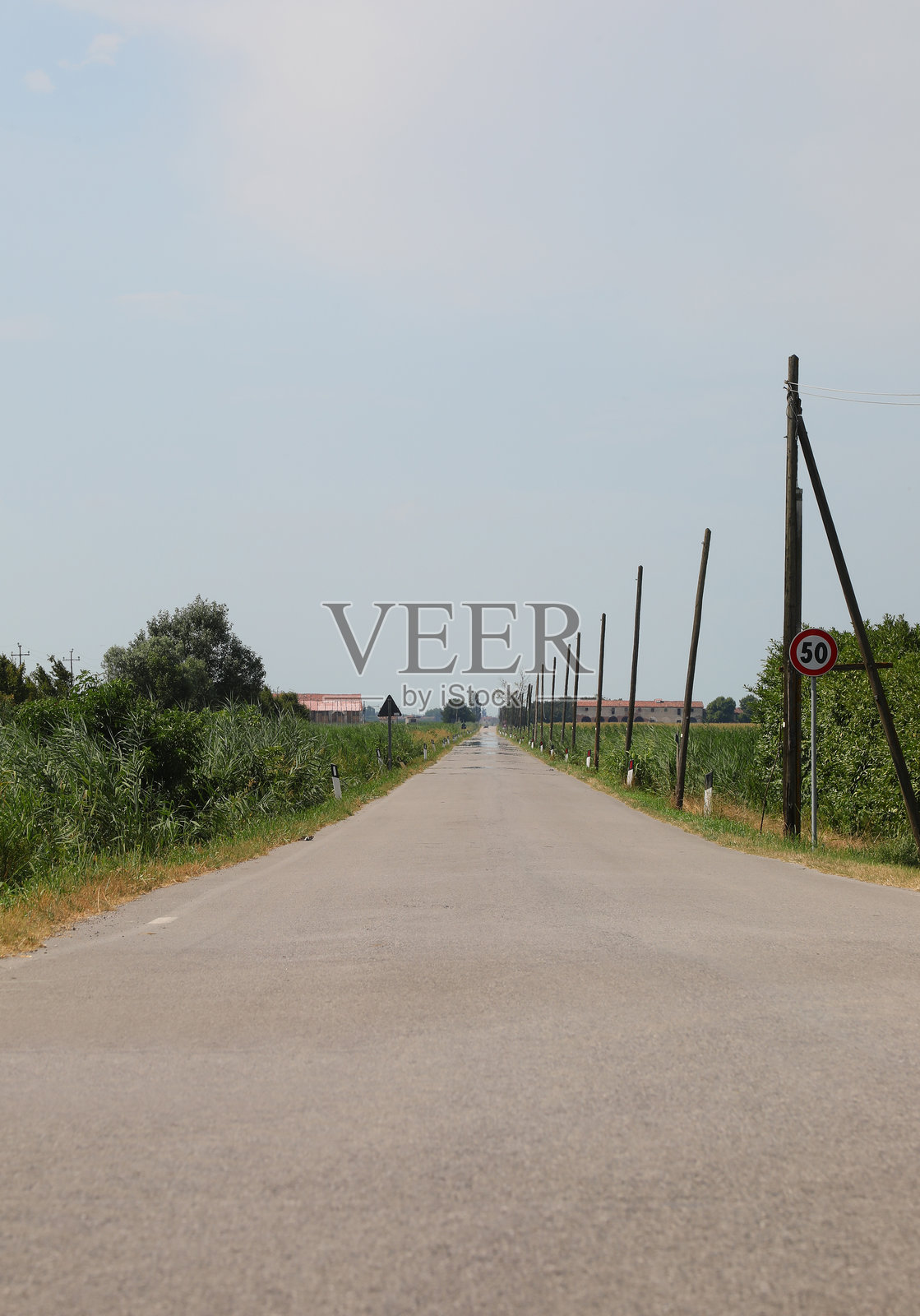 平原上一条笔直荒芜的道路，两侧有木桩，空旷的风景照片摄影图片