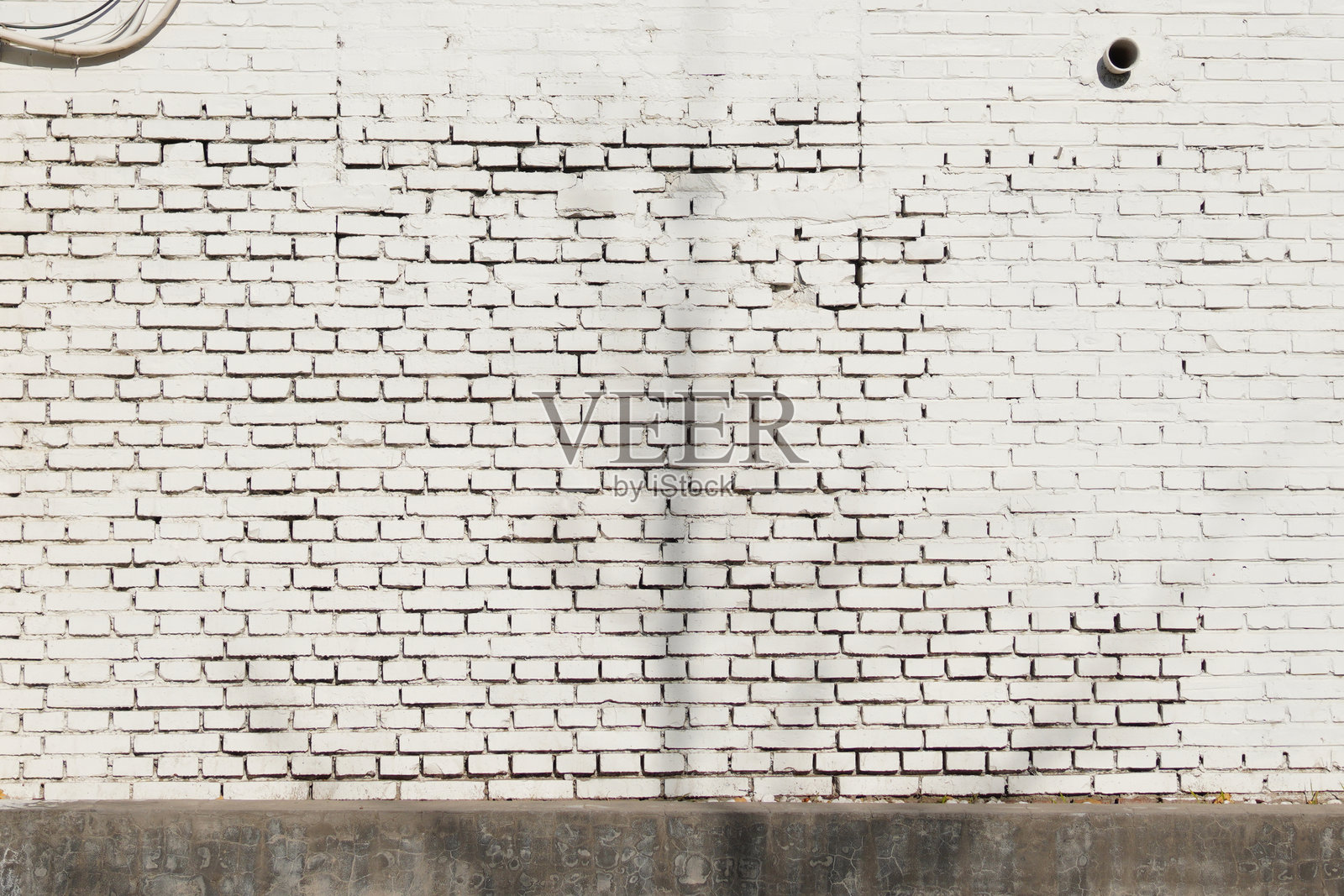 带有缝隙和一处小孔的白色砖墙照片摄影图片