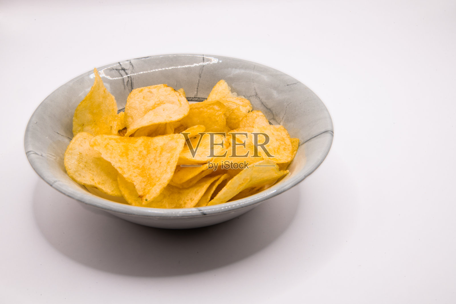 灰色碗里的薯片，纯白背景照片摄影图片