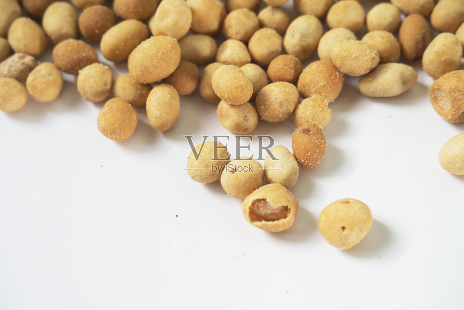 白色表面上金黄酥脆裹粉的坚果照片摄影图片