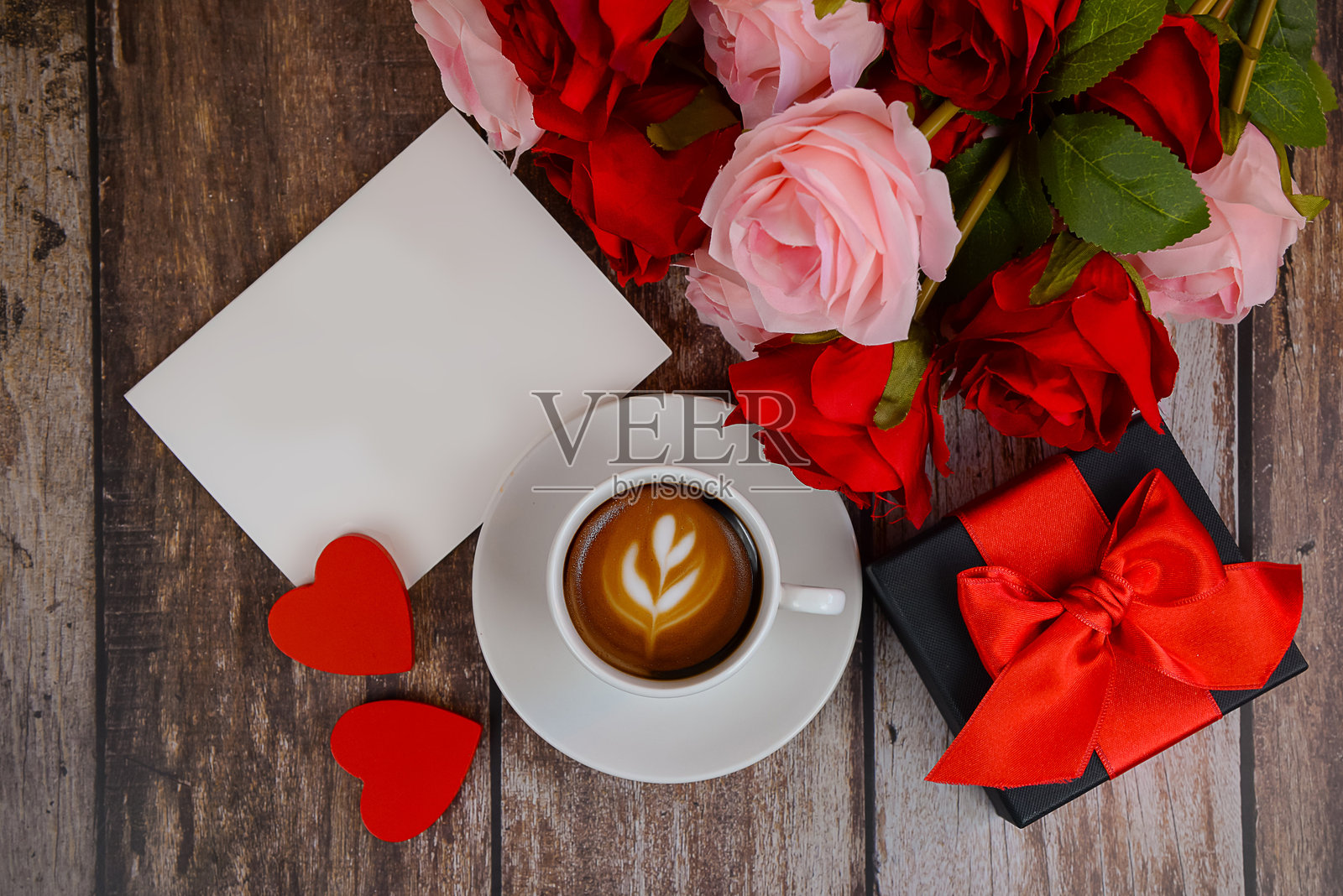 木桌上的情人节概念，包含咖啡杯、鲜花、礼物和贺卡照片摄影图片