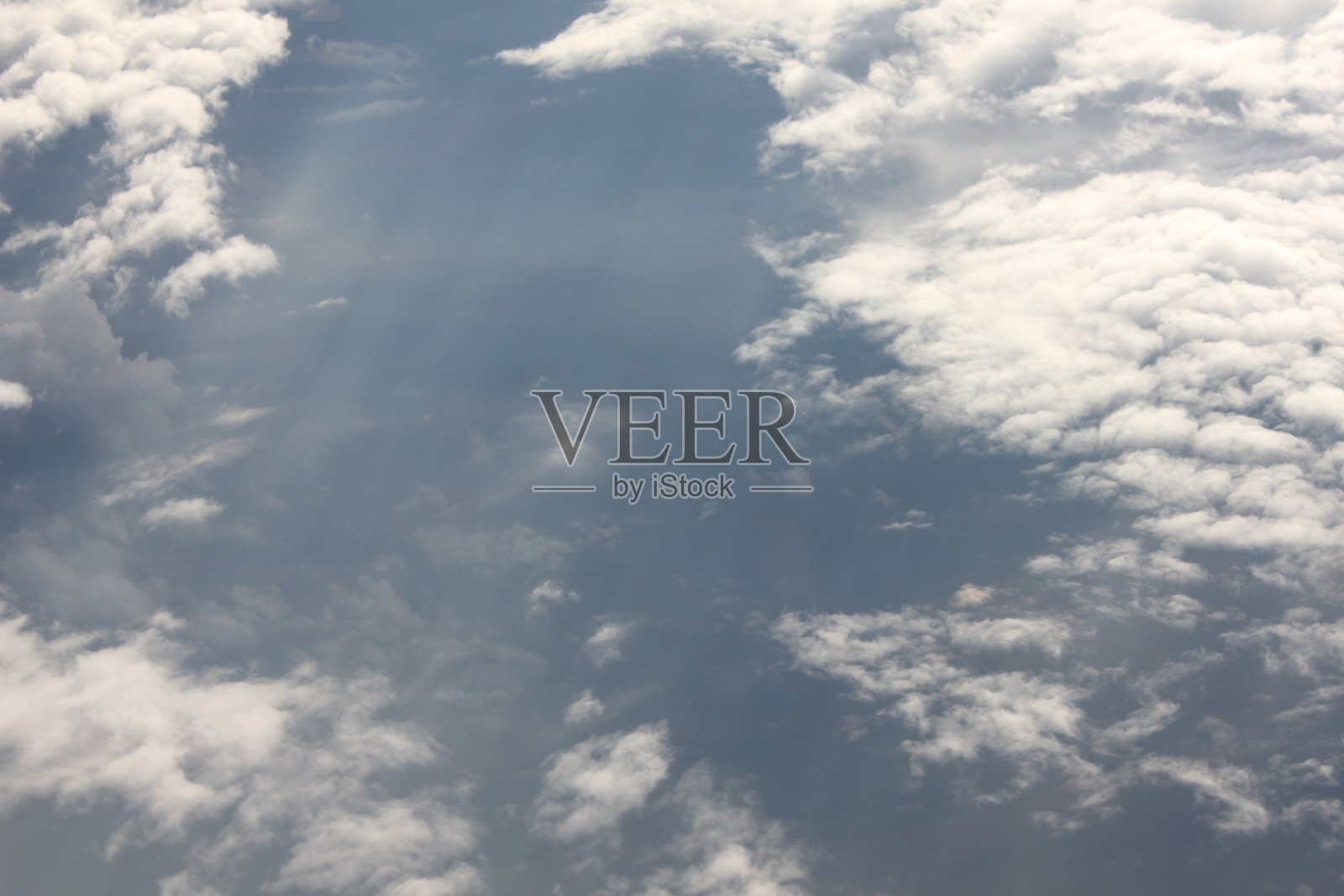 从飞机窗户看到的空中景象，下方是厚厚的云层，呈现出戏剧性的云景。照片摄影图片