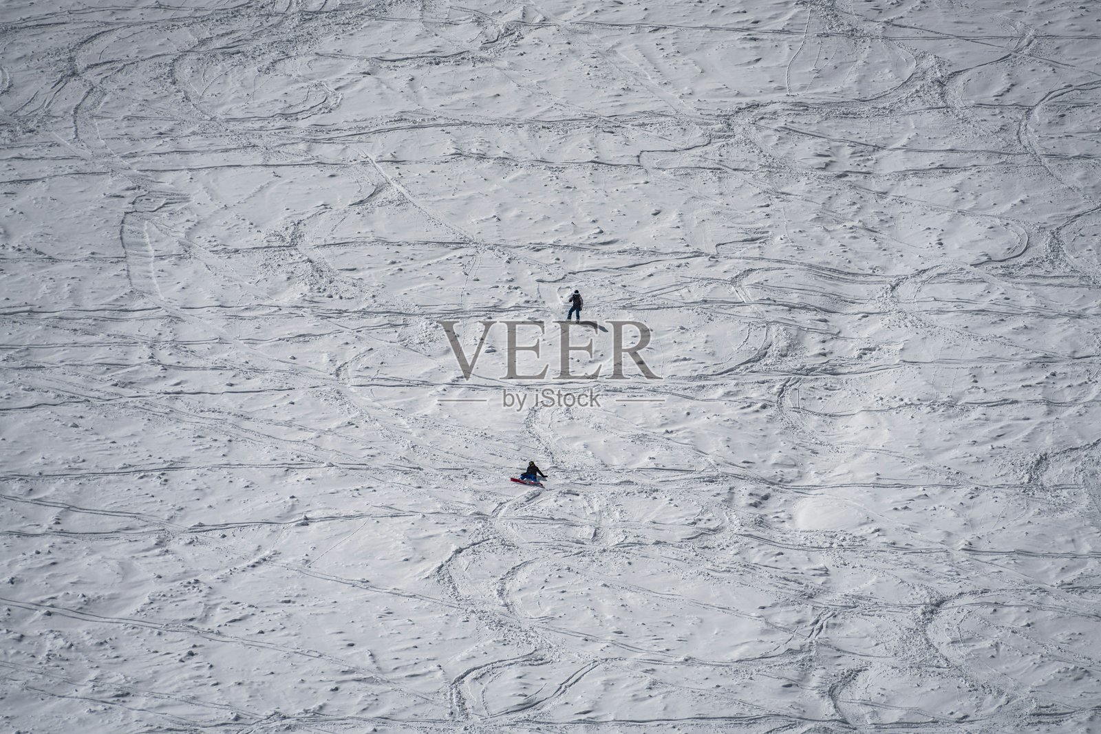 航拍画面：两名滑雪者在山坡的松软新雪上滑行照片摄影图片