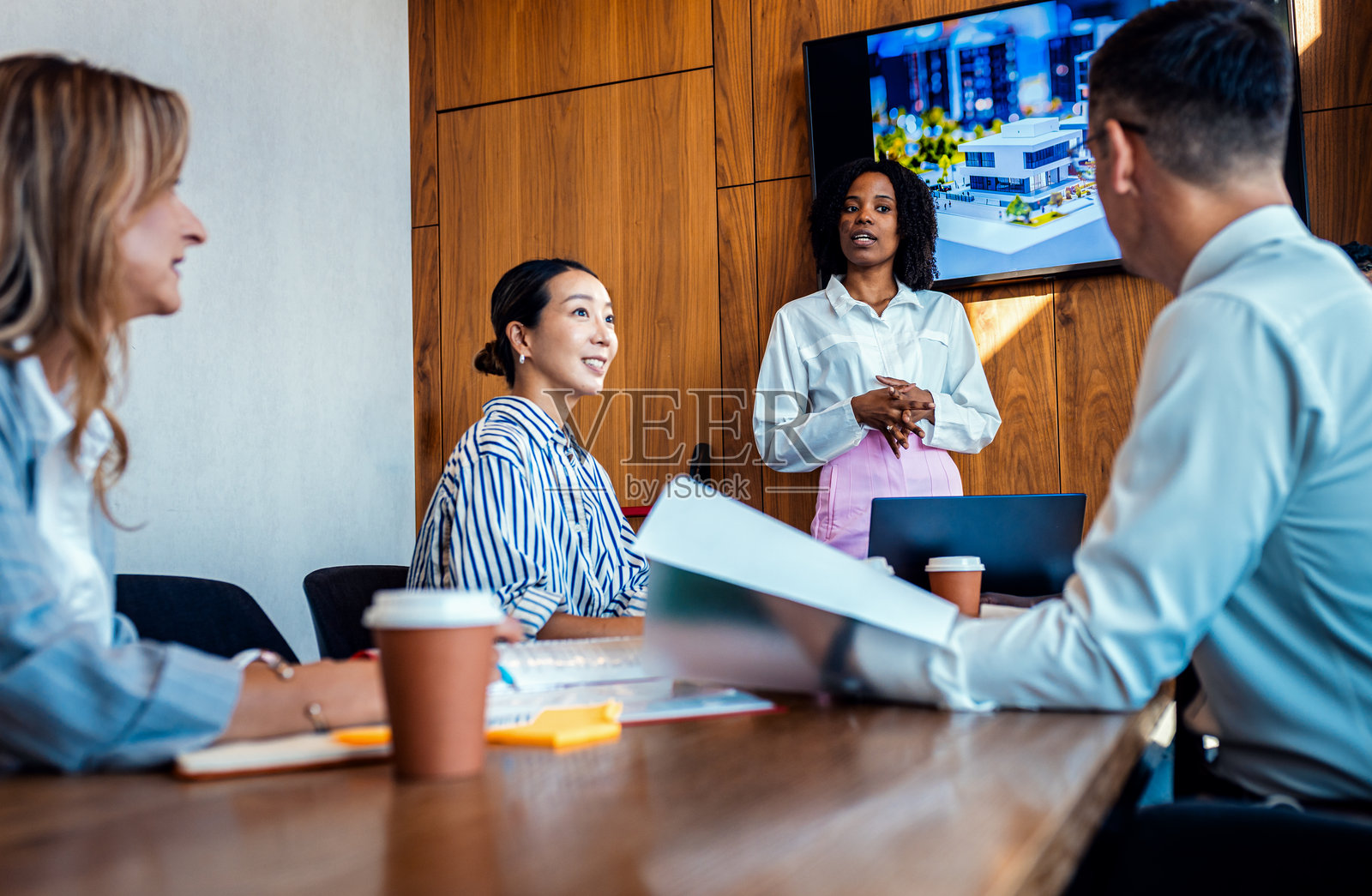 一群多元化的商务人士在会议室讨论建筑设计和规划。照片摄影图片