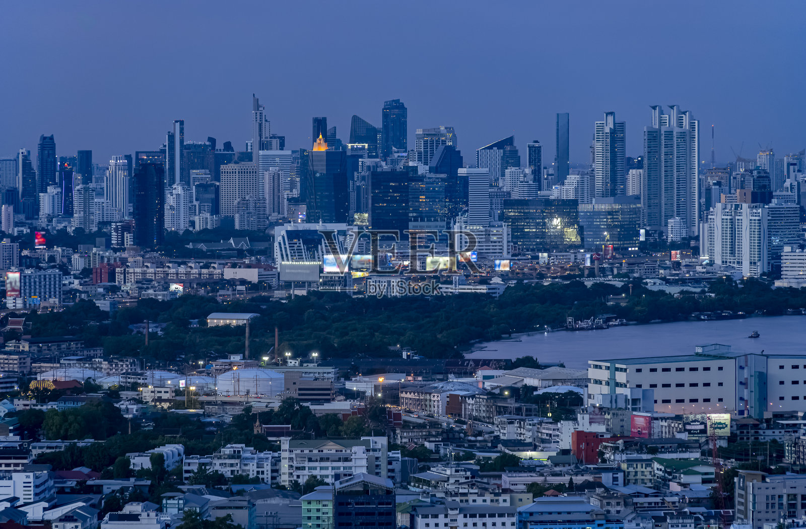 曼谷黄昏全景。深蓝色天空与市中心摩天大楼的灯光和湄南河的美丽曲线形成鲜明对比。照片摄影图片