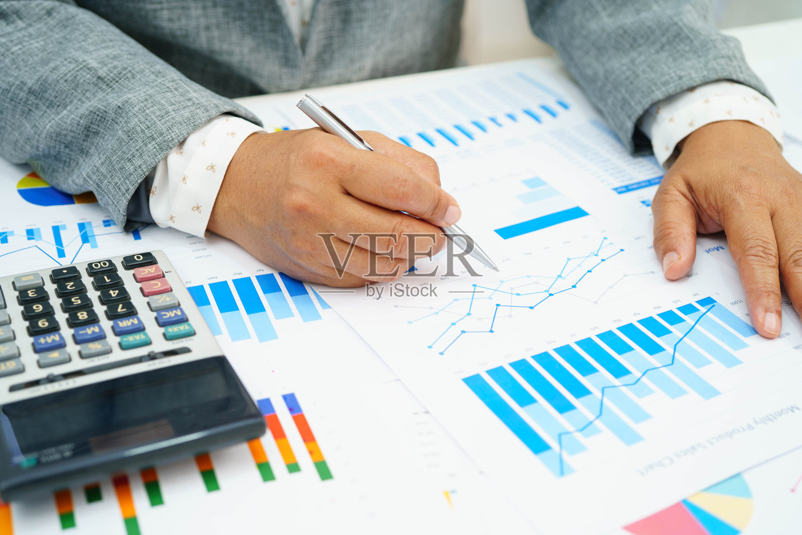 亚洲女商人使用财务图表工作。照片摄影图片