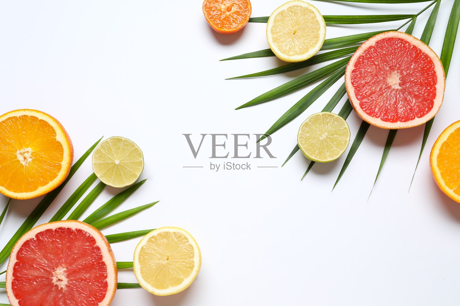明亮的背景，上面有各种水果。白色桌子上摆放着色彩鲜艳的新鲜水果，包括橙子、青柠、柠檬和葡萄柚。俯视角度拍摄，留有复制空间。照片摄影图片