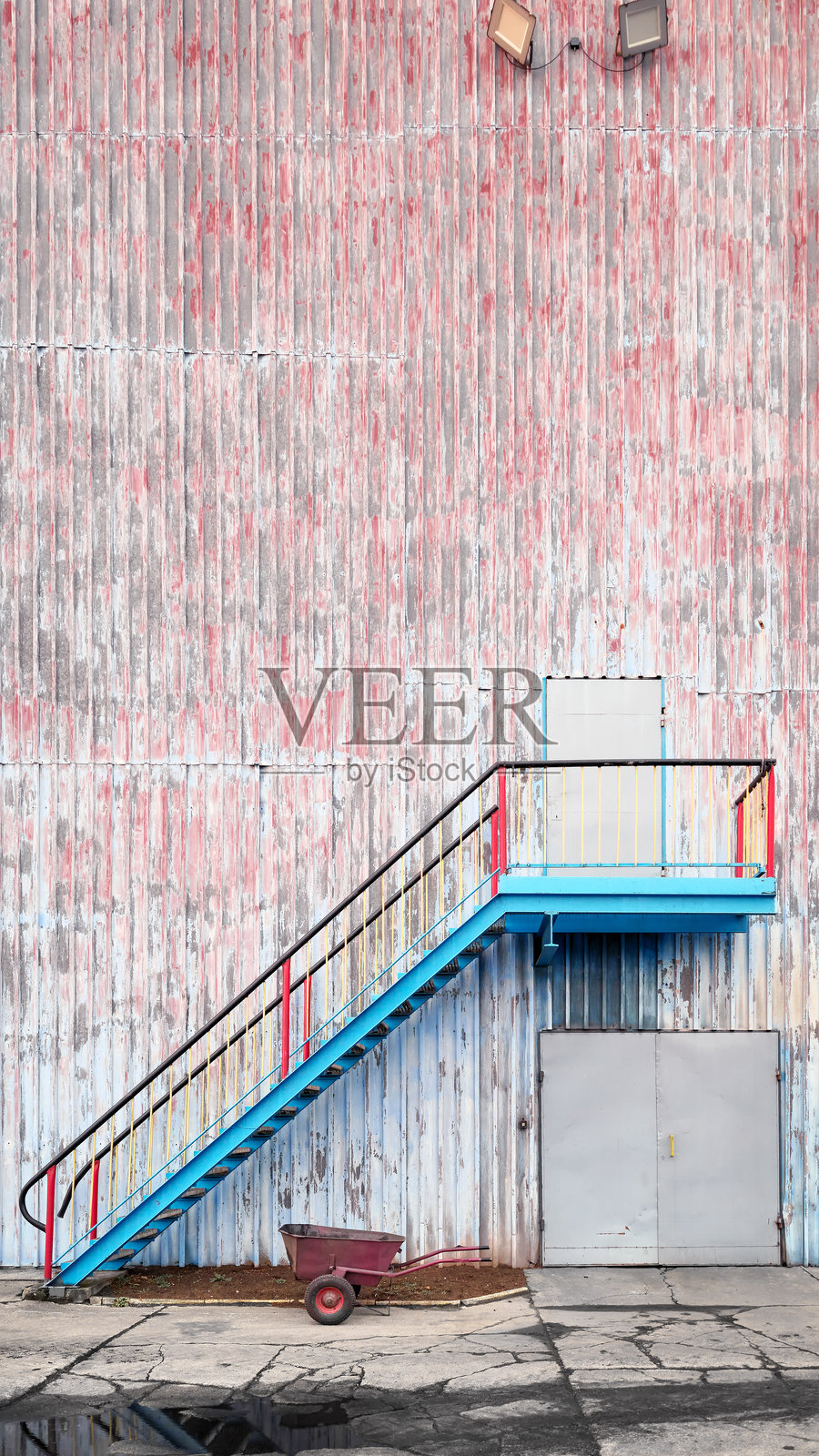 老旧工业建筑的墙壁，带有楼梯和手推车照片摄影图片
