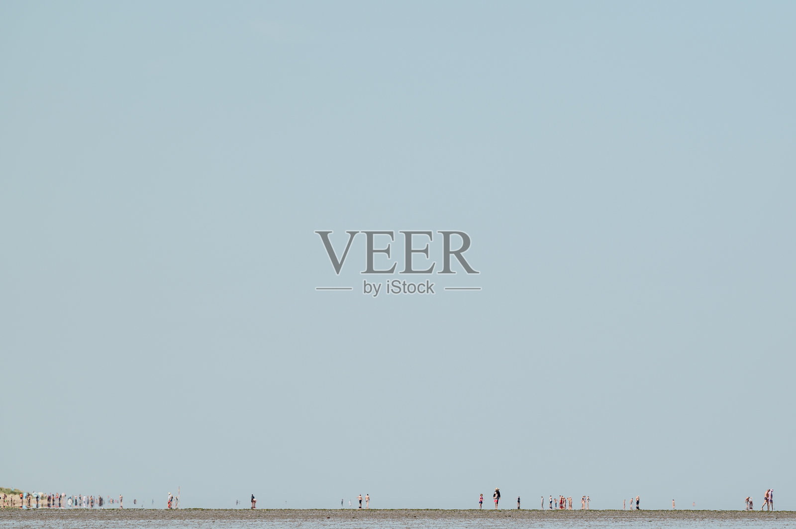 夏日炎炎，瓦登海地平线上模糊的人群。照片摄影图片