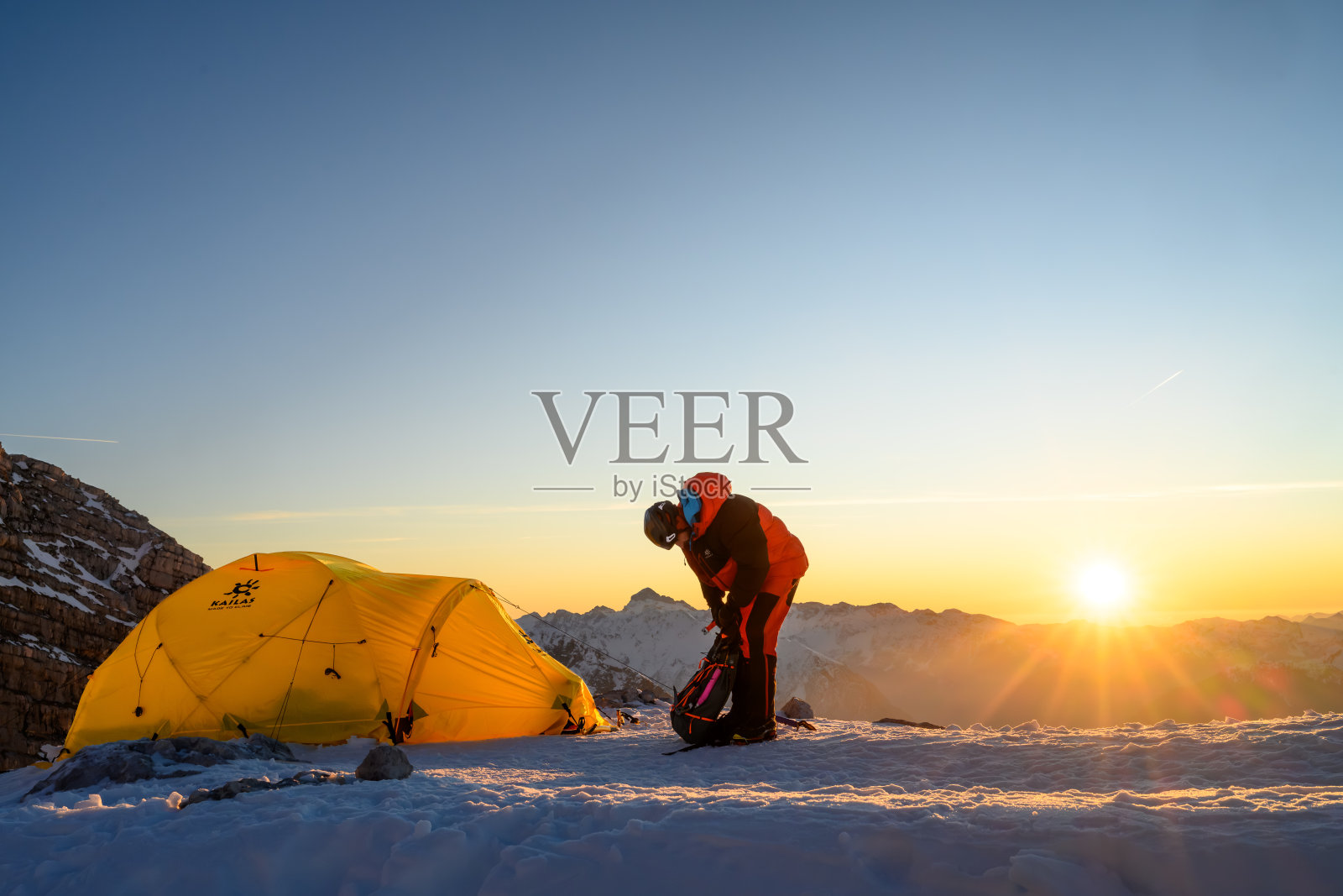 经验丰富的登山者在日出时在高山大本营整理装备照片摄影图片