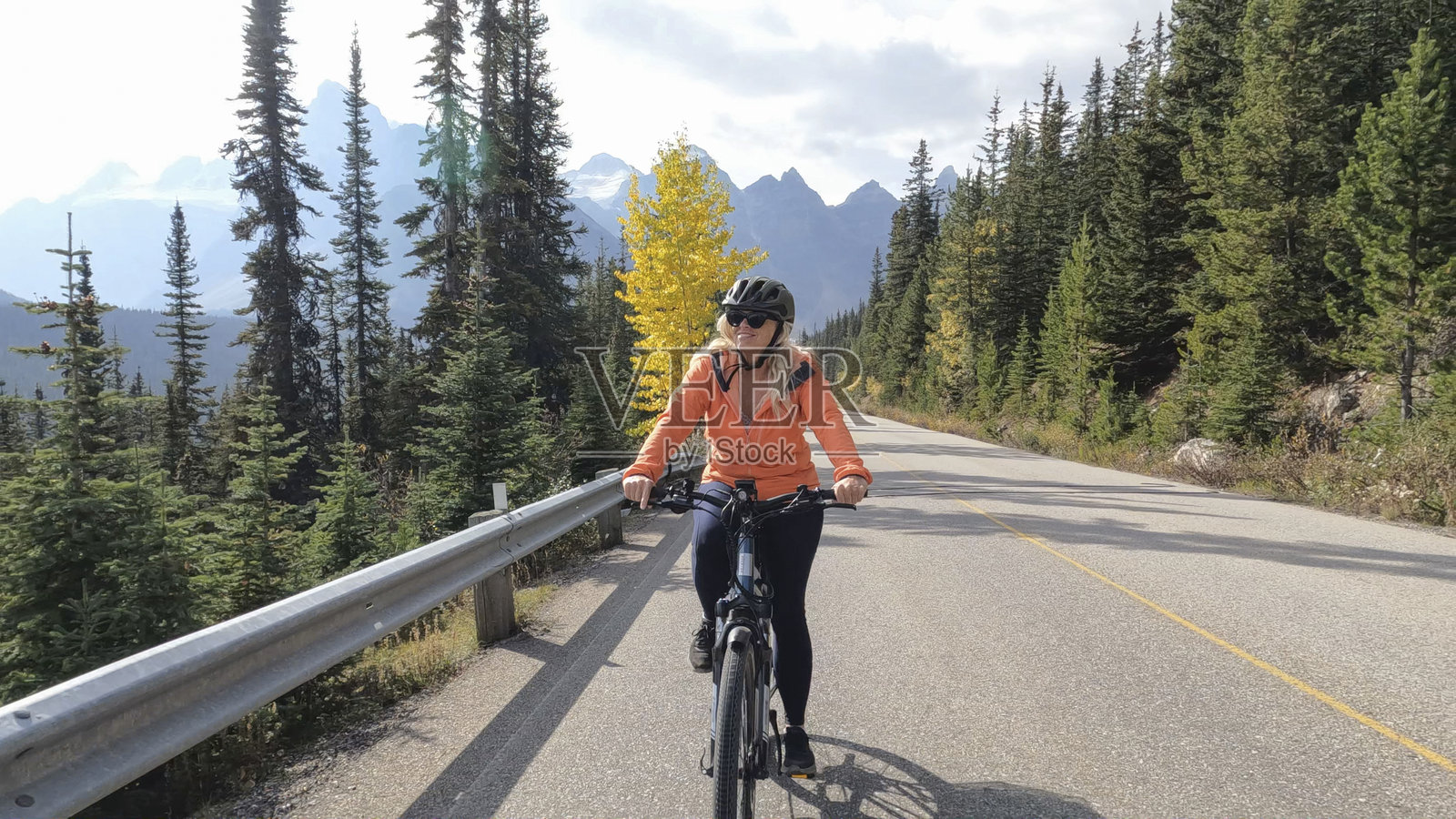 女子在山路上骑行电动自行车照片摄影图片