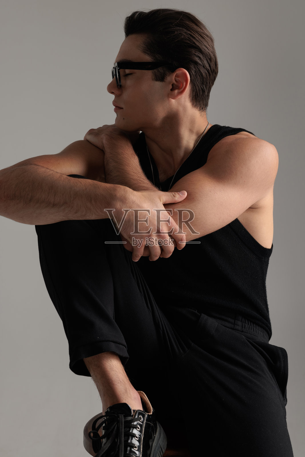 英俊的年轻男子拥抱自己，侧过头，闭上眼睛照片摄影图片