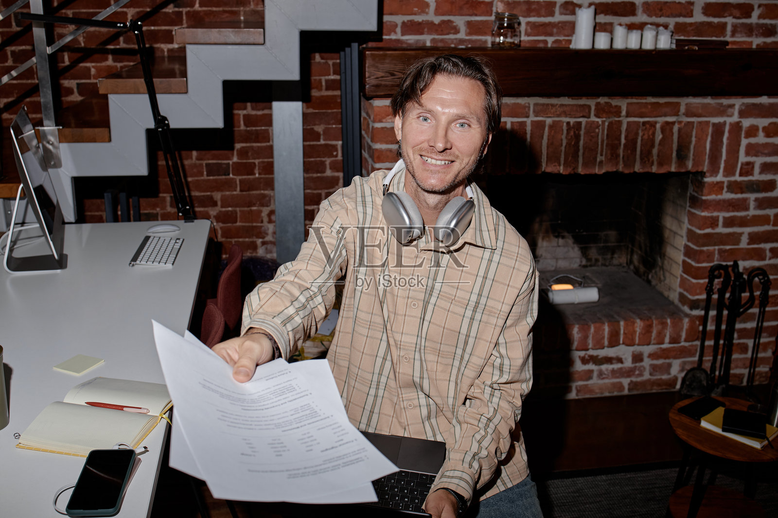 白种年轻成年男性在现代办公室递交文件时微笑照片摄影图片