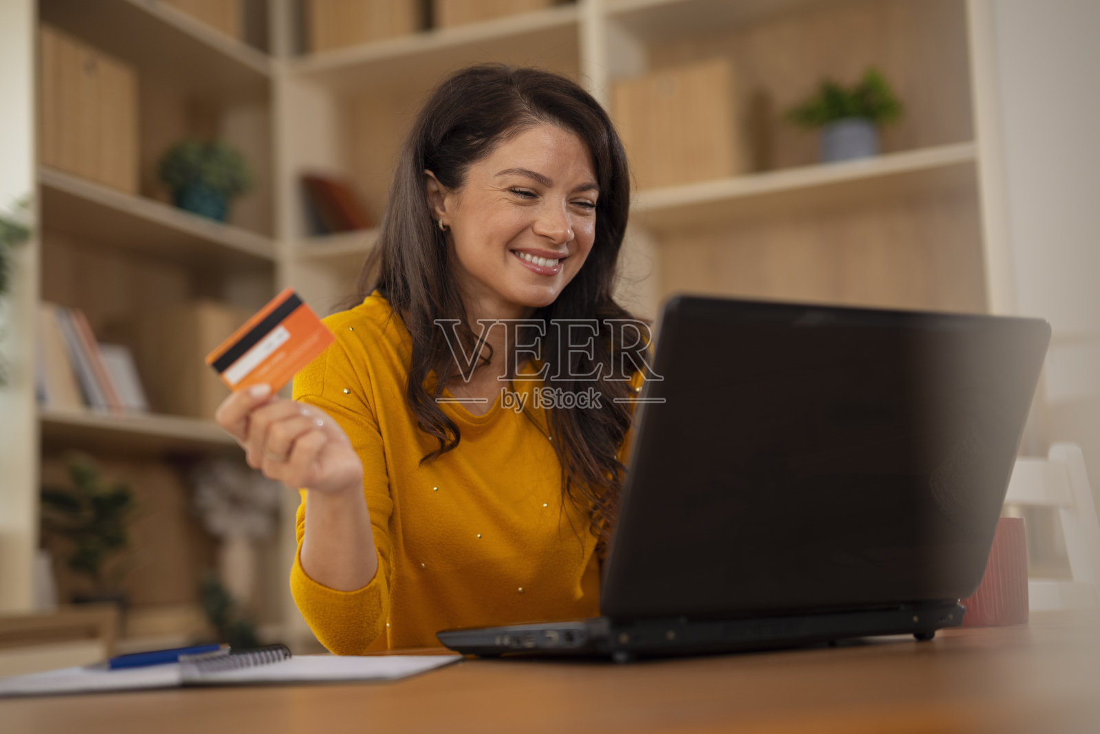 女性在笔记本电脑上使用信用卡进行在线购物支付照片摄影图片