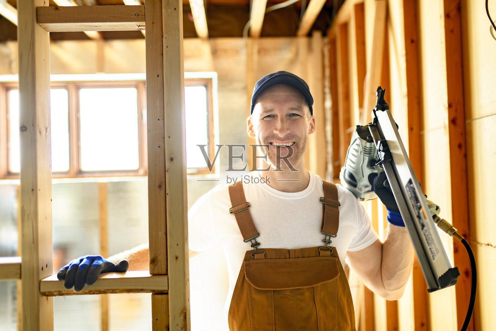 工人使用钉枪建造地下室房间照片摄影图片