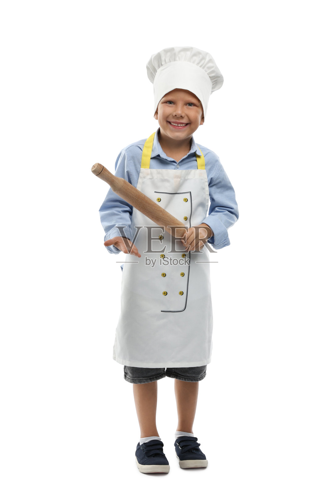 职业选择。小男孩假装大厨，手里拿着擀面杖，背景为白色照片摄影图片