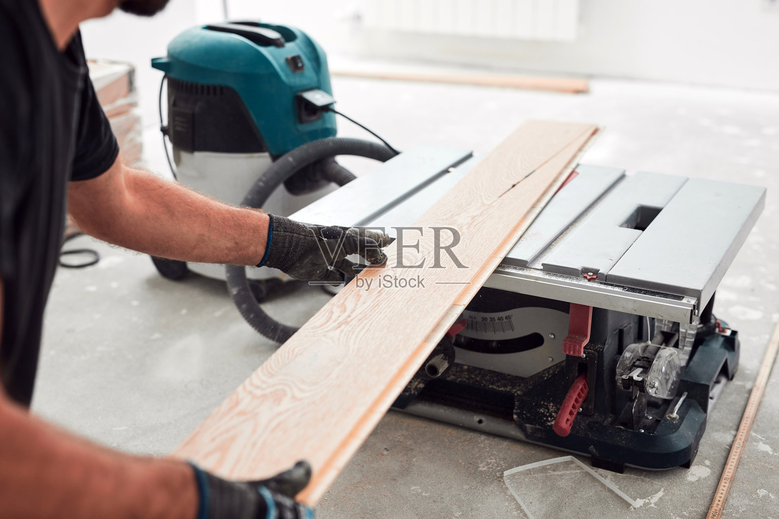 专业装修工人在新公寓里铺设复合地板。照片摄影图片