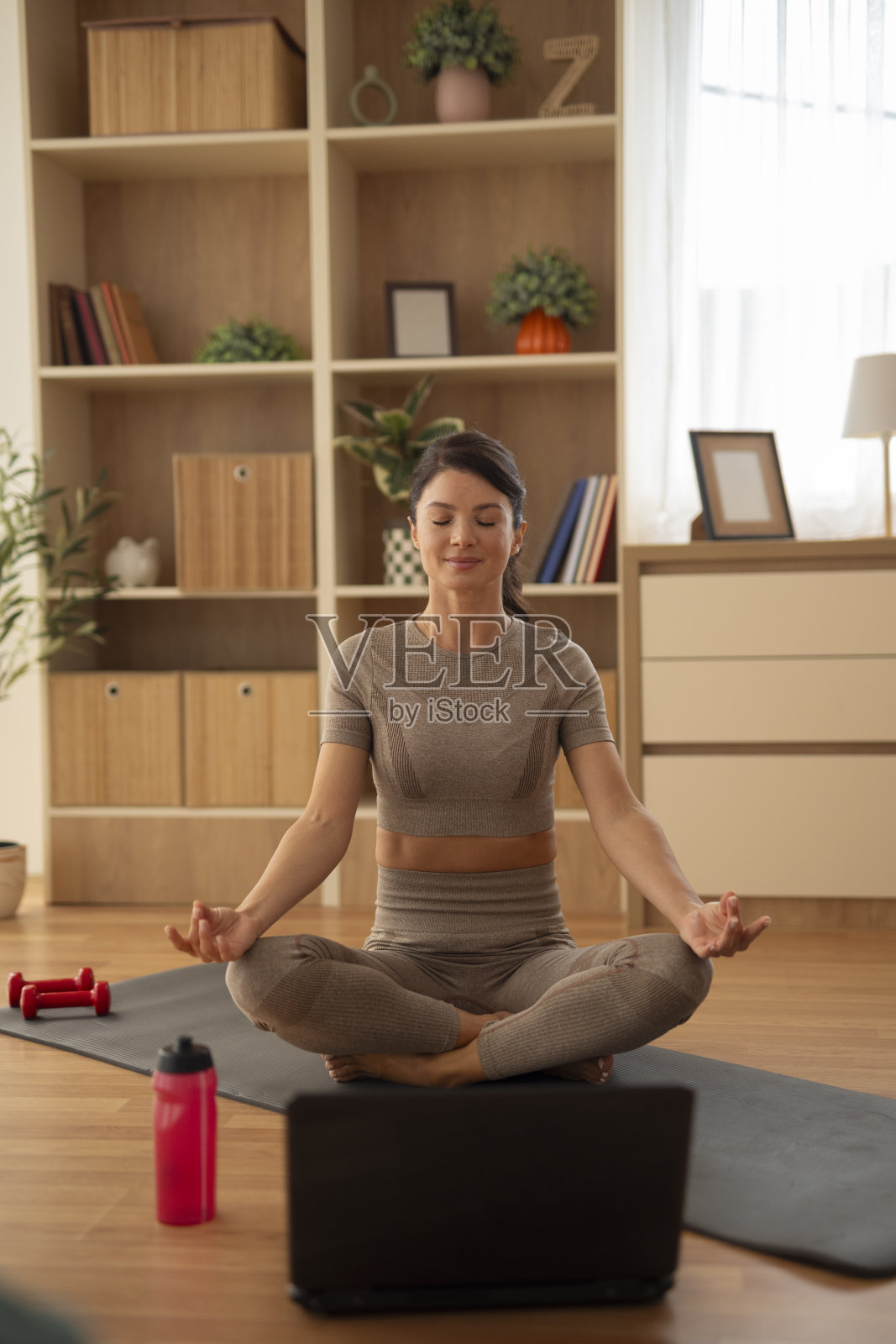 女子在家参加线上瑜伽课时冥想照片摄影图片