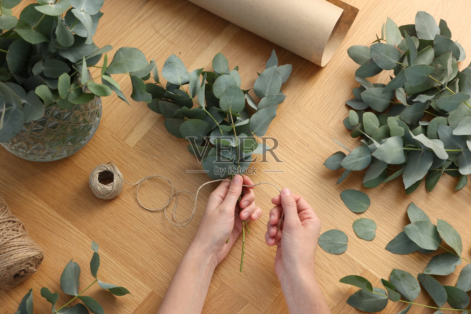 花艺师在木桌上制作精美的桉树枝花束，俯视角度照片摄影图片