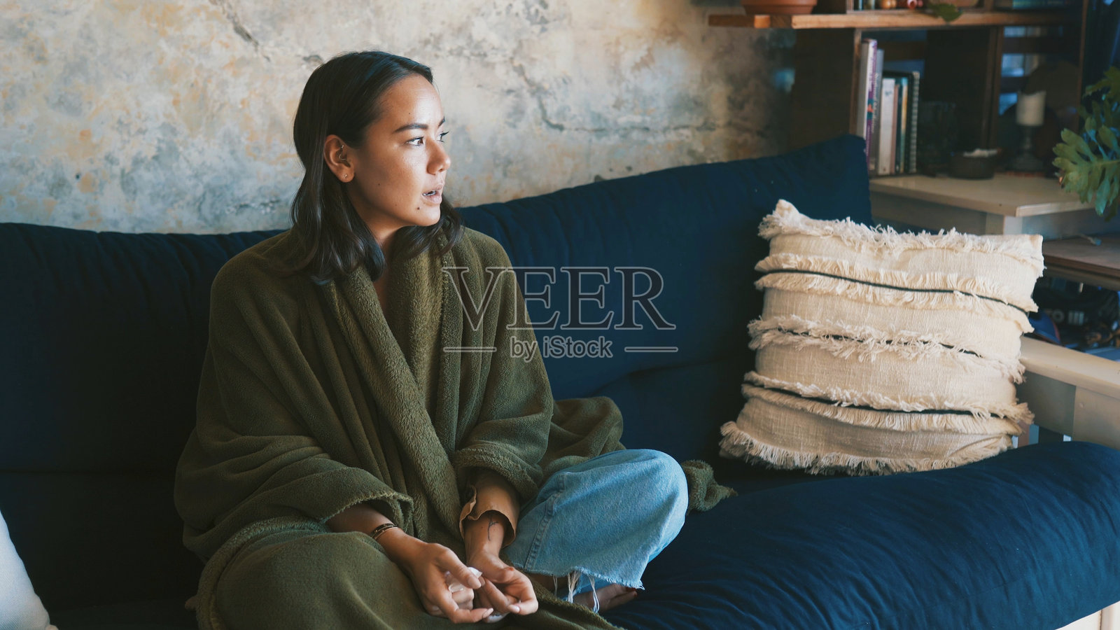 一名女性在家中沙发上生病，在公寓客厅的早晨，带着周末休息的平静和沉思，思考着，安静而专注。照片摄影图片