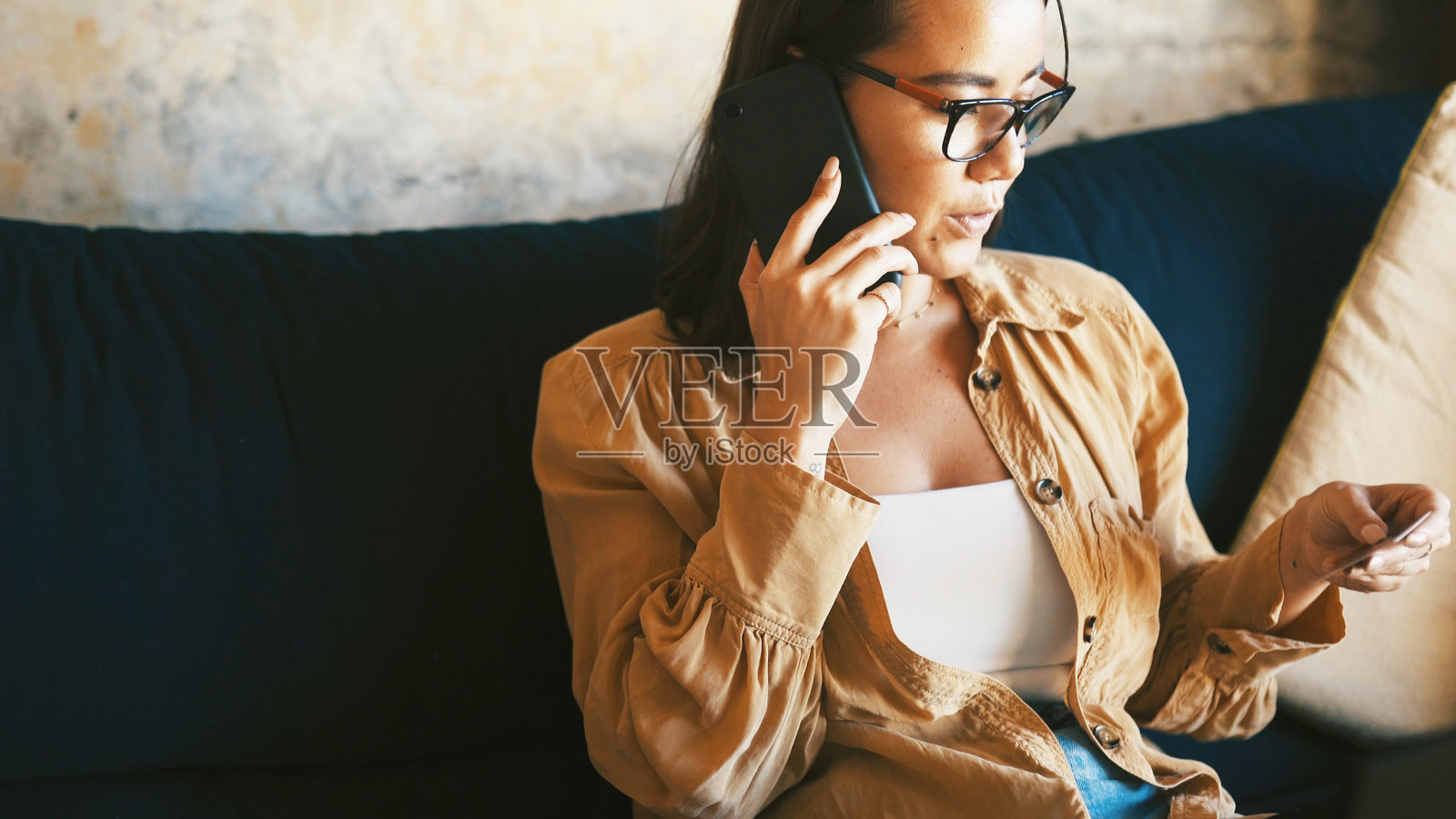 女性在沙发上进行电话、信用卡和应用程序操作，用于电子商务、金融科技和数字支付。在家中客厅里，人们进行网上银行、密码验证和账户 PIN 操作以完成订单。照片摄影图片