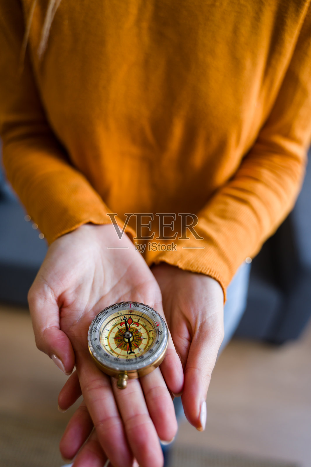 一位女士手持旧指南针，寻找未来的方向和指引照片摄影图片