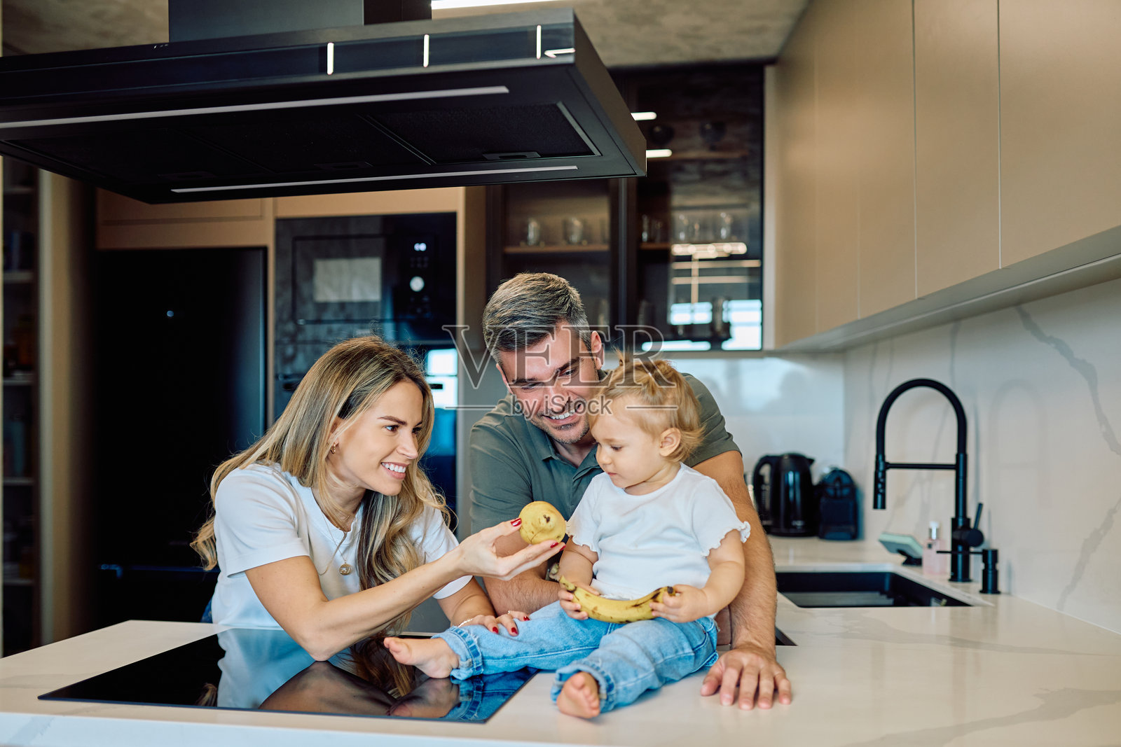 一家人在现代厨房享用健康食品照片摄影图片