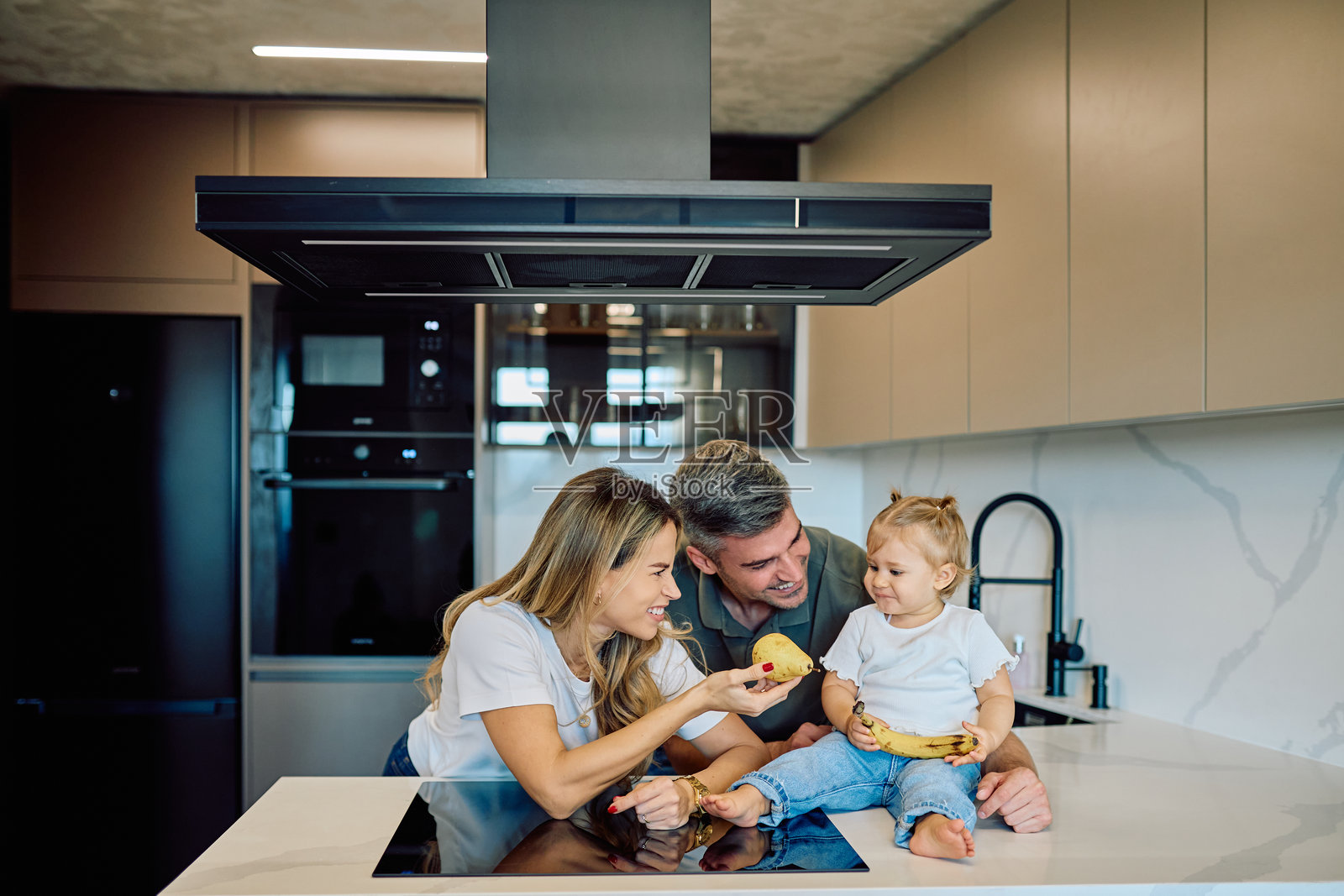 一家人在厨房享用健康新鲜的水果照片摄影图片