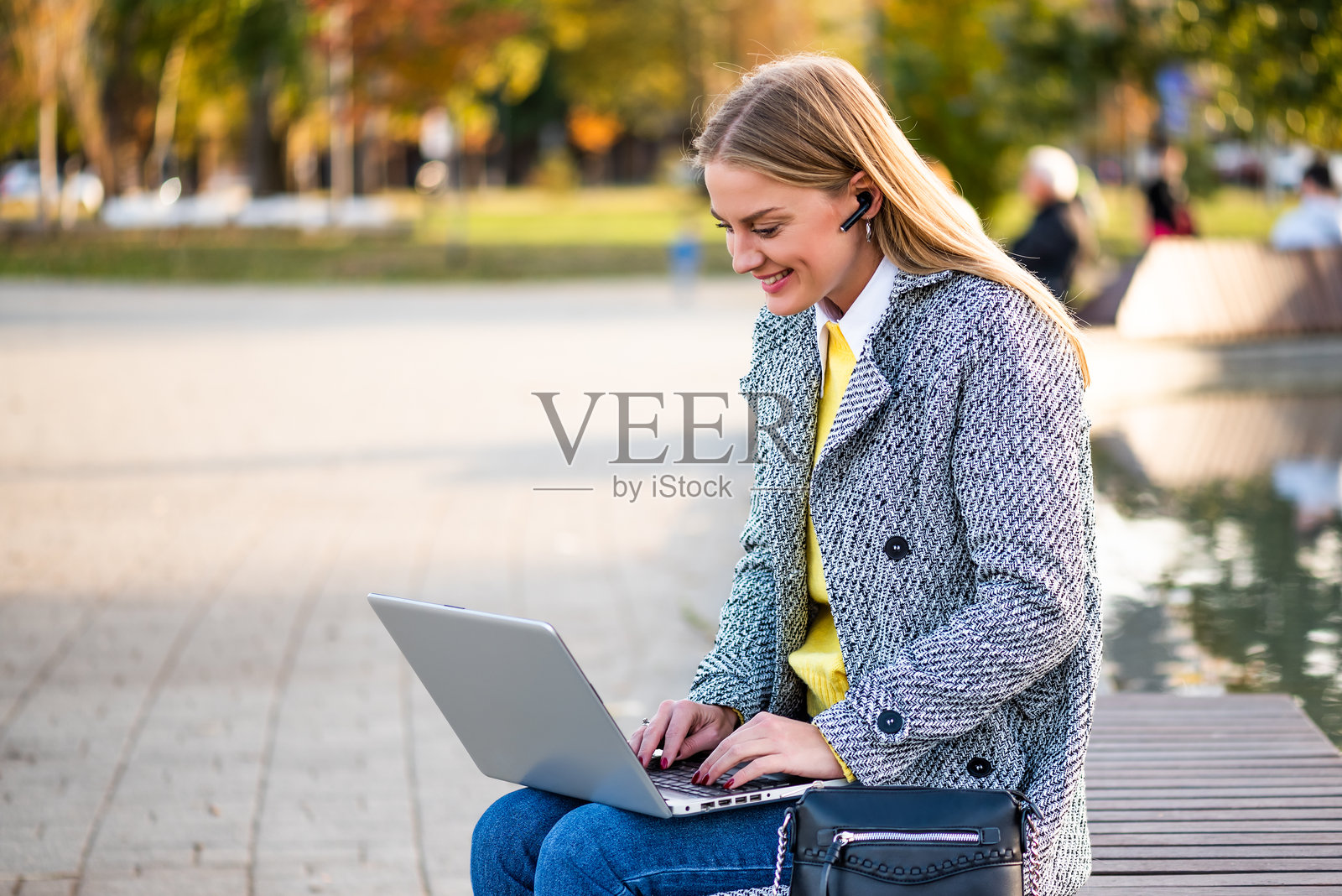 现代女性在城市公园通过笔记本电脑参加在线会议照片摄影图片
