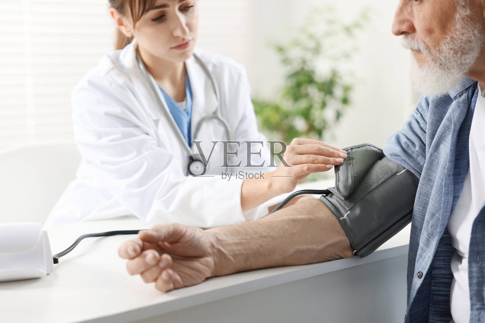 医生在就诊时近距离为老年男性测量血压照片摄影图片