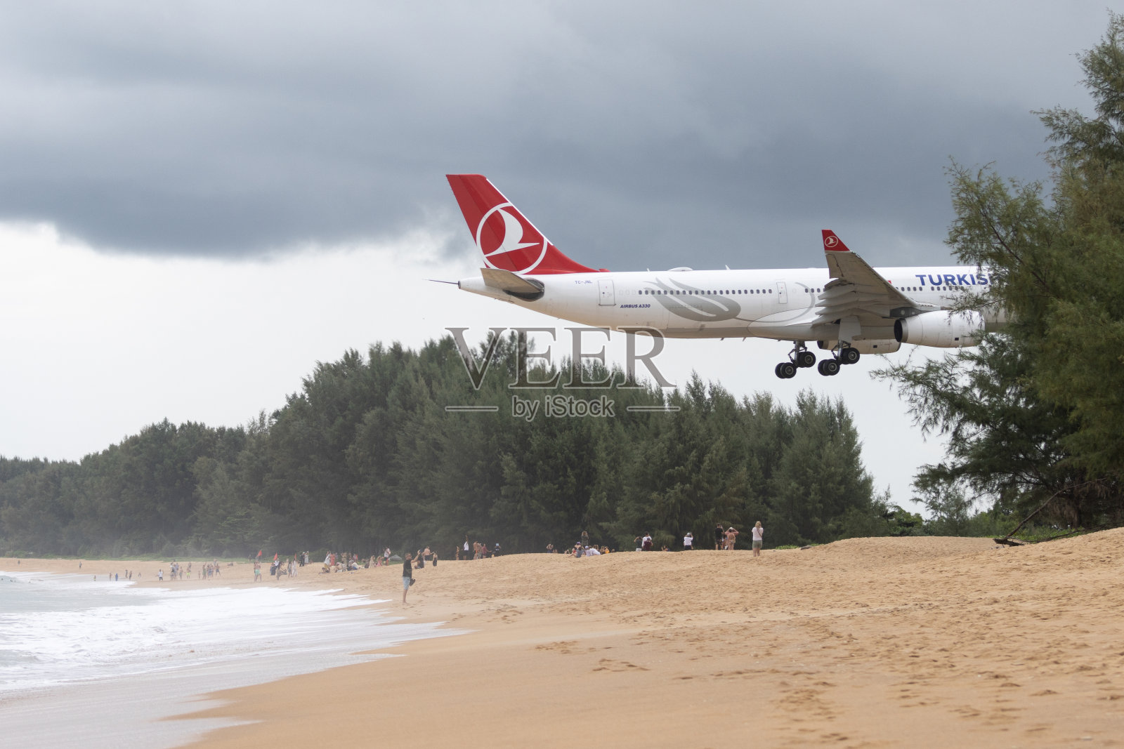 土耳其航空的飞机准备在迈考海滩的普吉国际机场降落。照片摄影图片