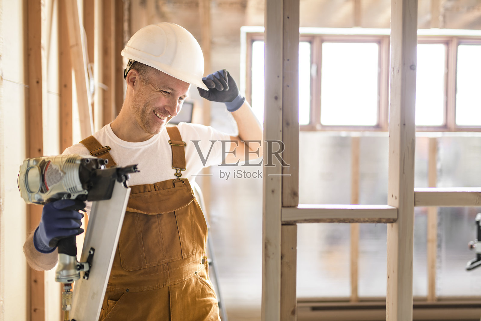 工人使用钉枪建造地下室房间照片摄影图片