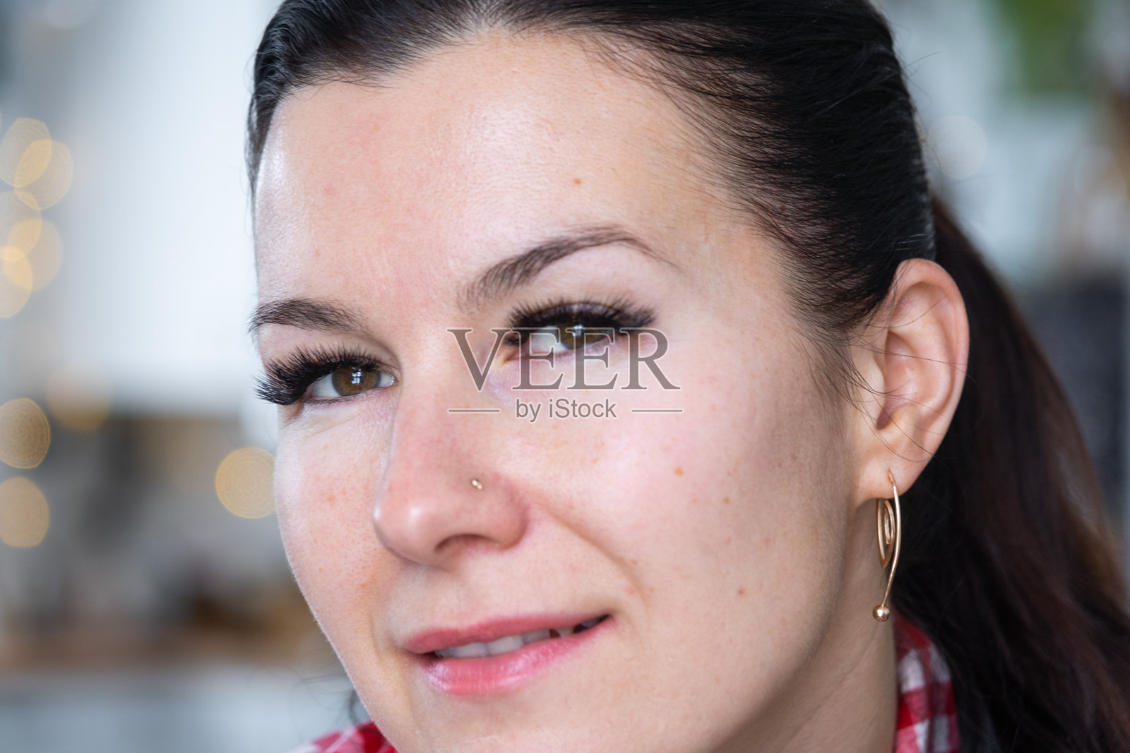 特写镜头中，一位女士拥有长长的假睫毛，上面点缀着水钻。为节日做准备。照片摄影图片