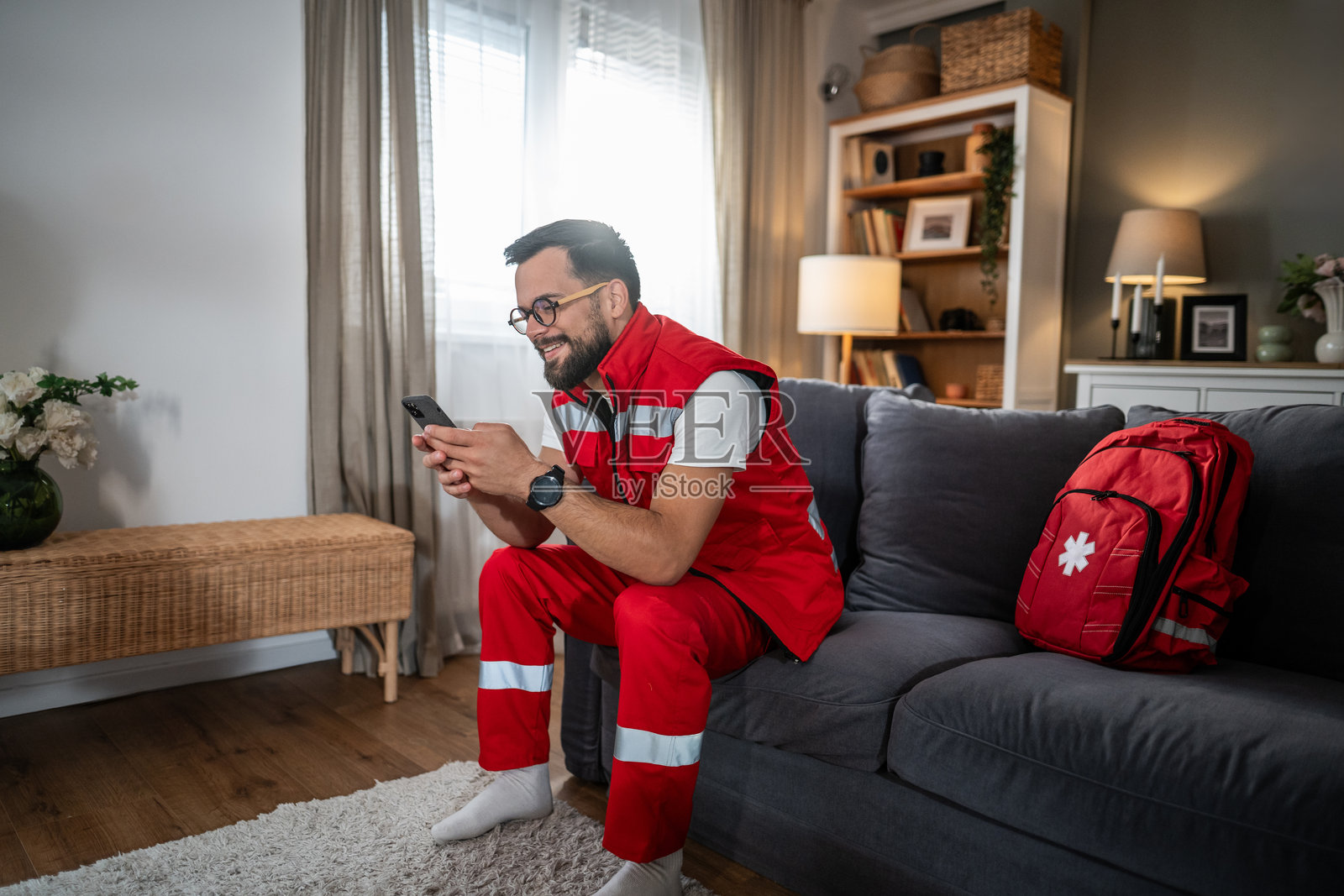 一位微笑的男性急救员在家中放松地用手机发消息照片摄影图片
