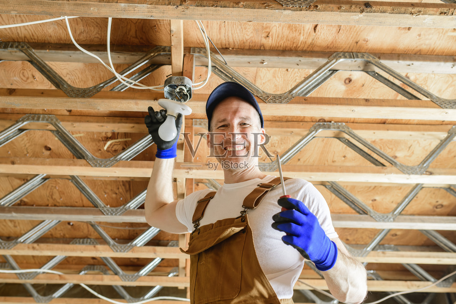 一名电工在地下室修理灯泡照片摄影图片