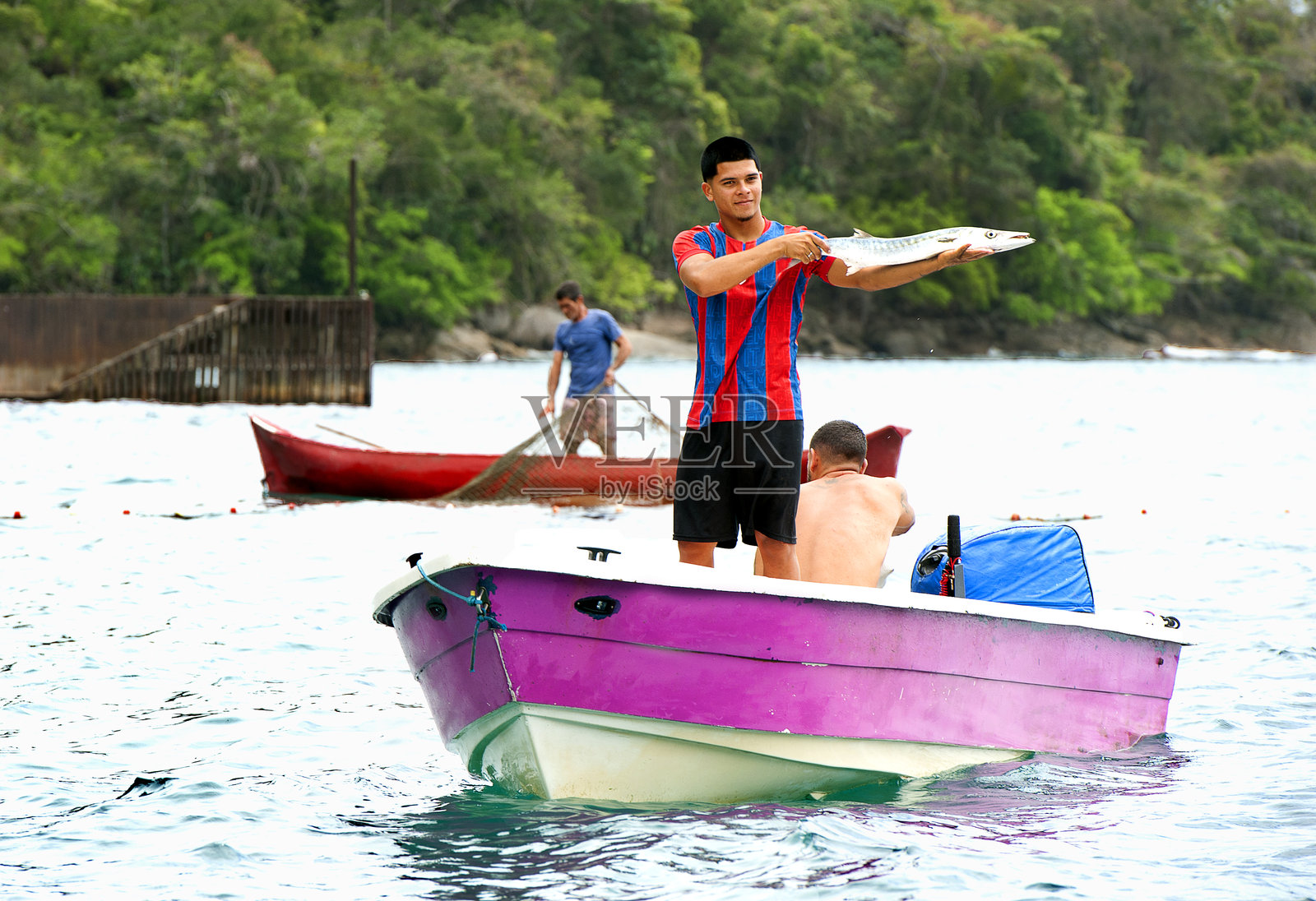 渔民自豪地展示他的渔获，位于巴西海岸的葡萄牙殖民小镇帕拉蒂照片摄影图片