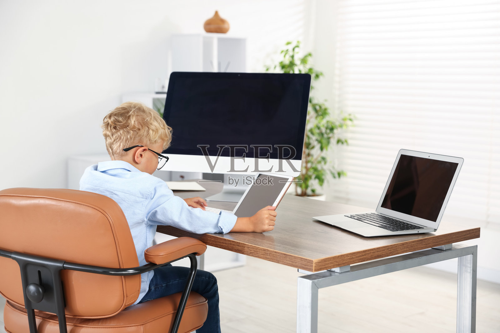 职业选择：小男孩假装在办公室工作照片摄影图片