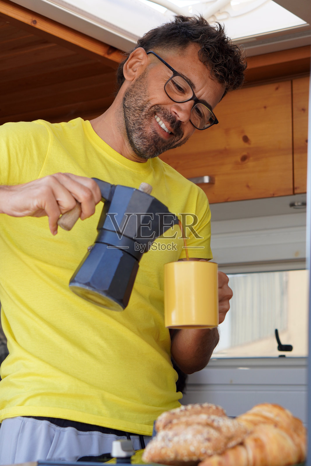 房车里的男人在冲咖啡。游牧生活。家庭旅行和度假。照片摄影图片