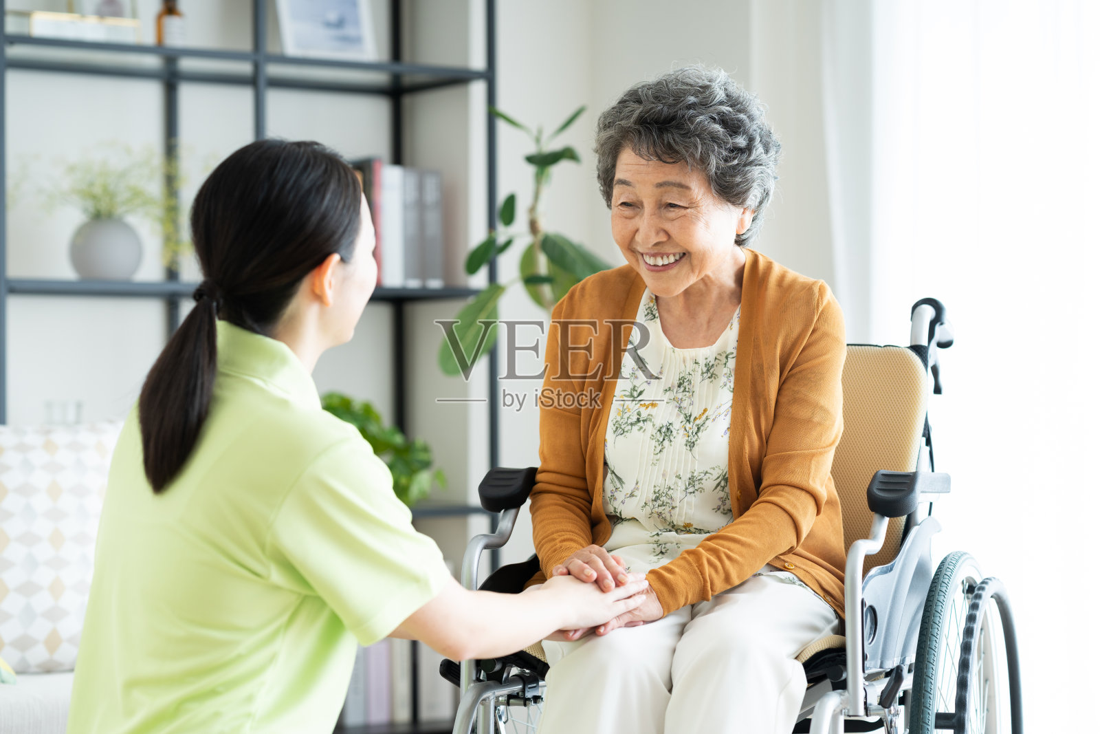 坐轮椅的老年女性和年轻女性护理员照片摄影图片