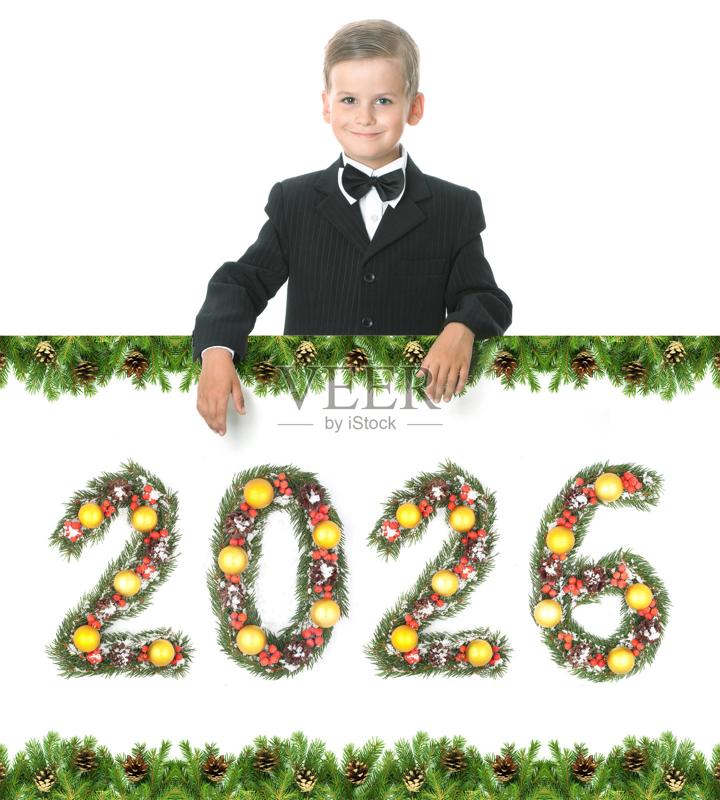 白底背景上，一个微笑的男孩手持写有数字“2026”的常青松枝横幅，周围装饰着松果边框，迎接圣诞新年。照片摄影图片