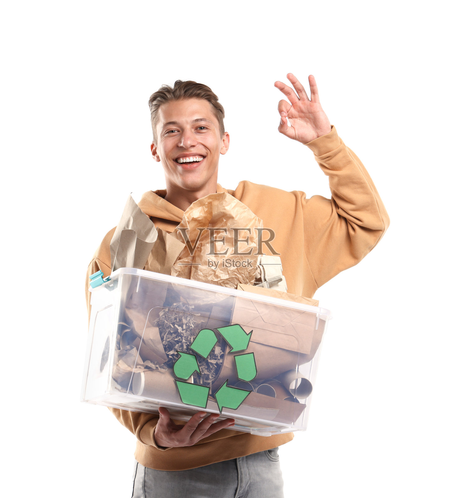 微笑的男子在白色背景上拿着装有不同废纸的塑料盒子，并竖起大拇指表示OK照片摄影图片