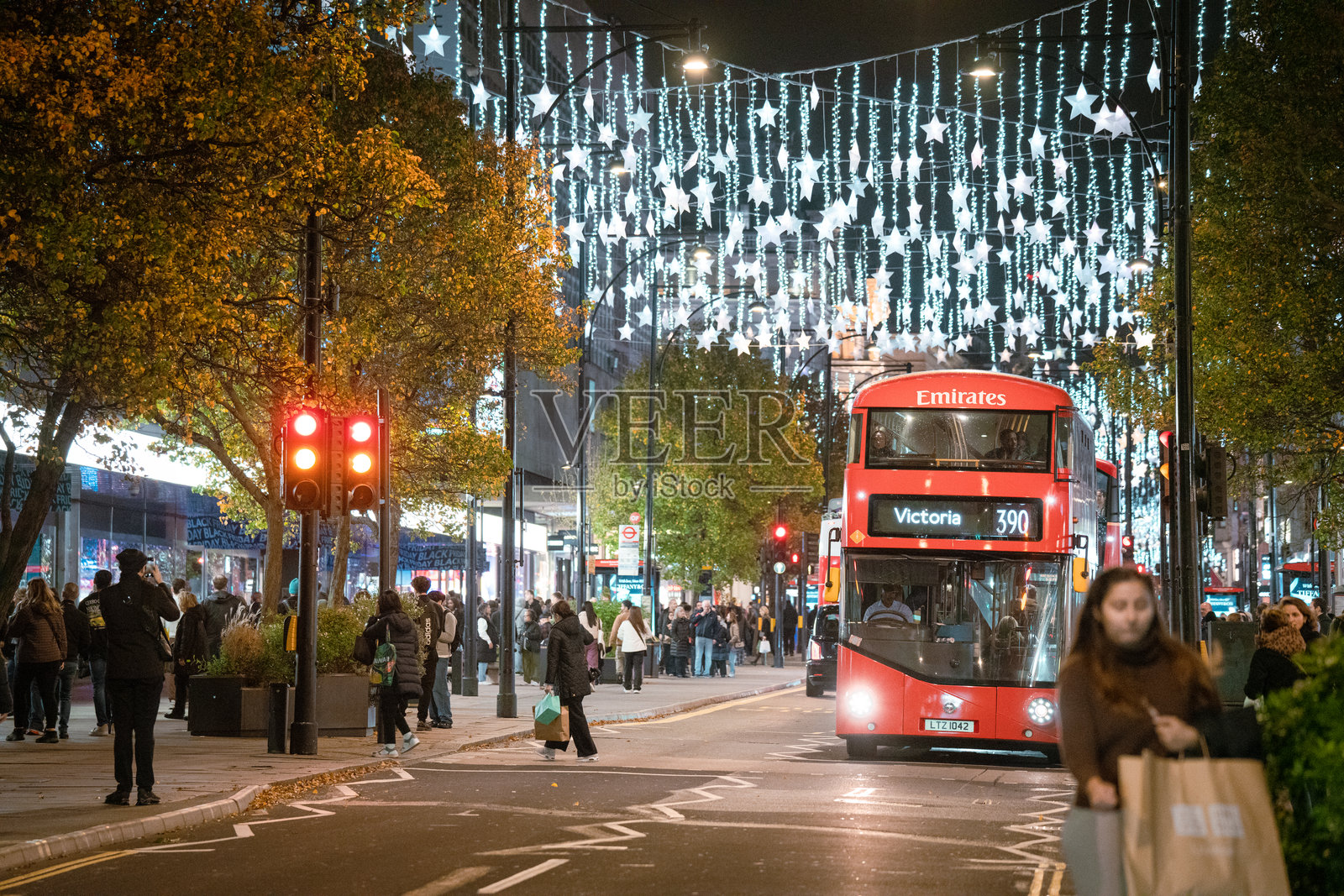圣诞灯饰，闪耀的星星节日装饰，红色双层巴士，牛津街夜景，伦敦市中心照片摄影图片