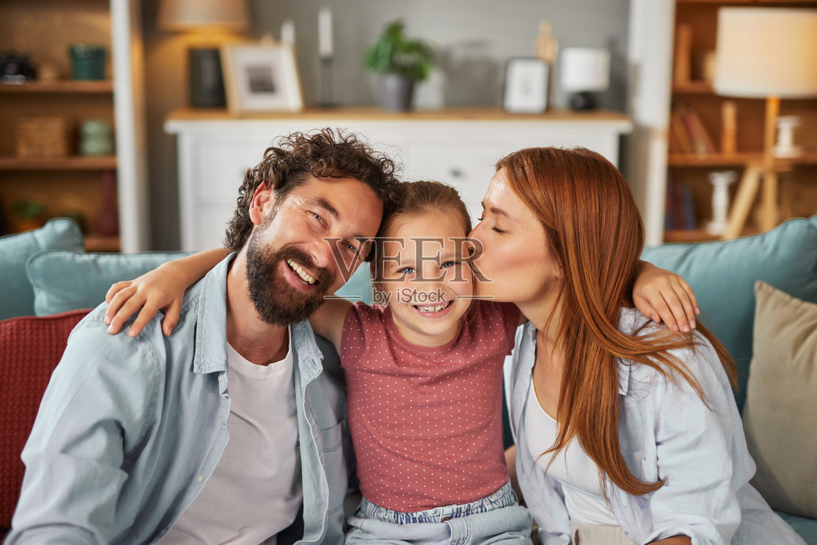 一家人开心地在沙发上拥抱微笑照片摄影图片