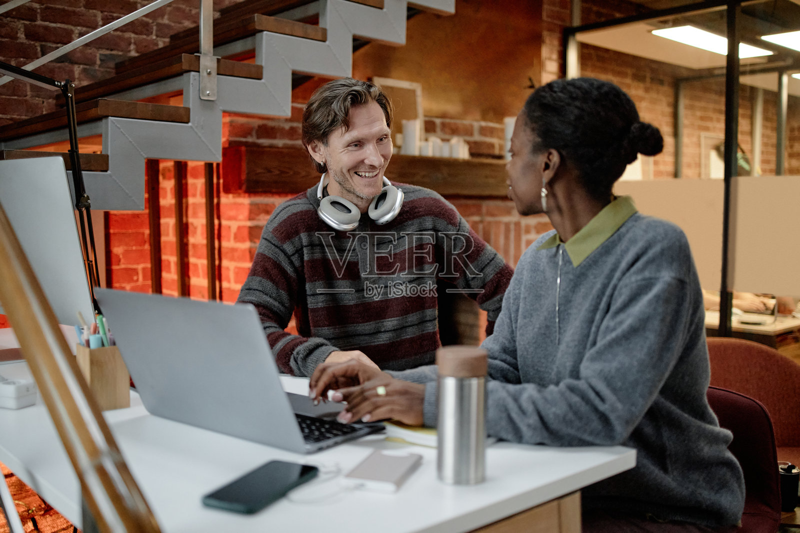 年轻的白人男性与中年黑人女性在办公室协作照片摄影图片