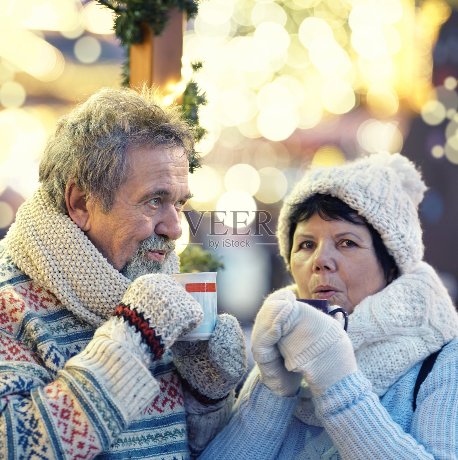 一对快乐的老年夫妇在圣诞集市上享用热红酒潘趣酒照片摄影图片